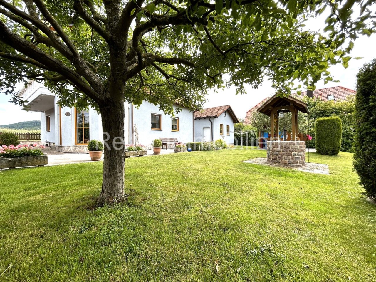 liebevoll gepflegter Garten mit Gartenhütte und Brunnen